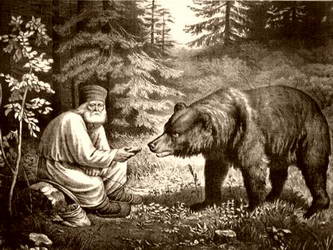 Отец Серафим кормит медведя